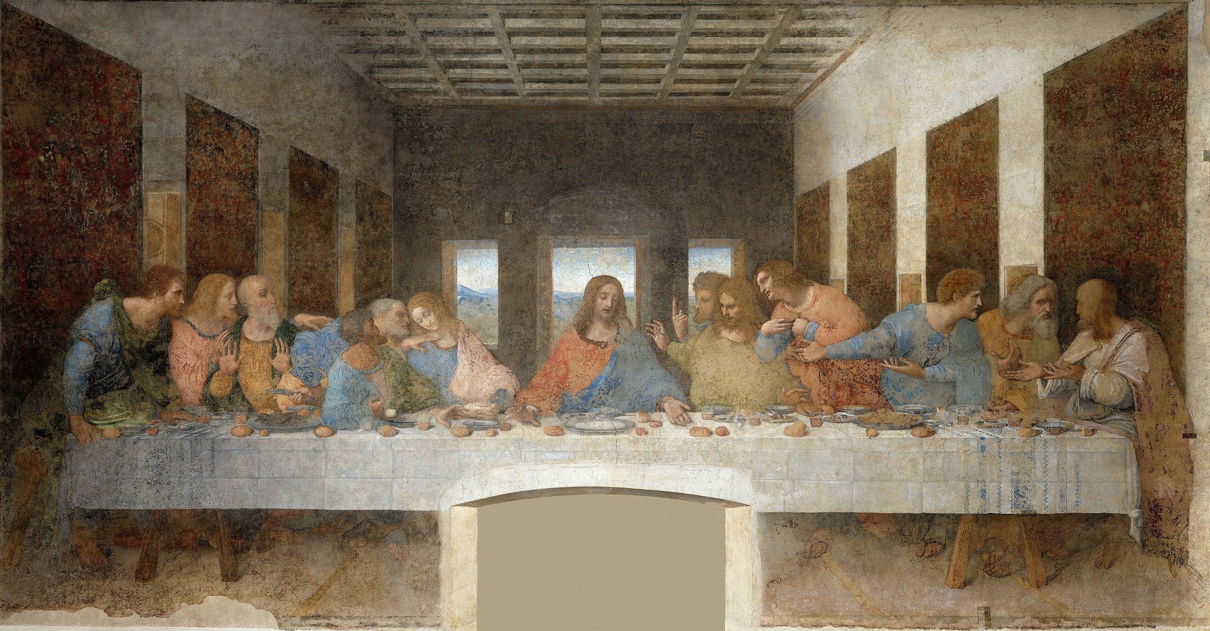 Mural of Christ and his twelve apostles seated at a long banquet table, with three windows in the wall behind.